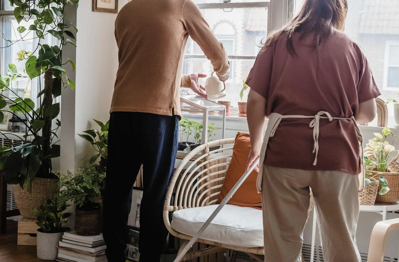 Zwei Personen reinigen einen Wohnraum als Beispiel für Reinigungsarbeiten im Haushalt.
